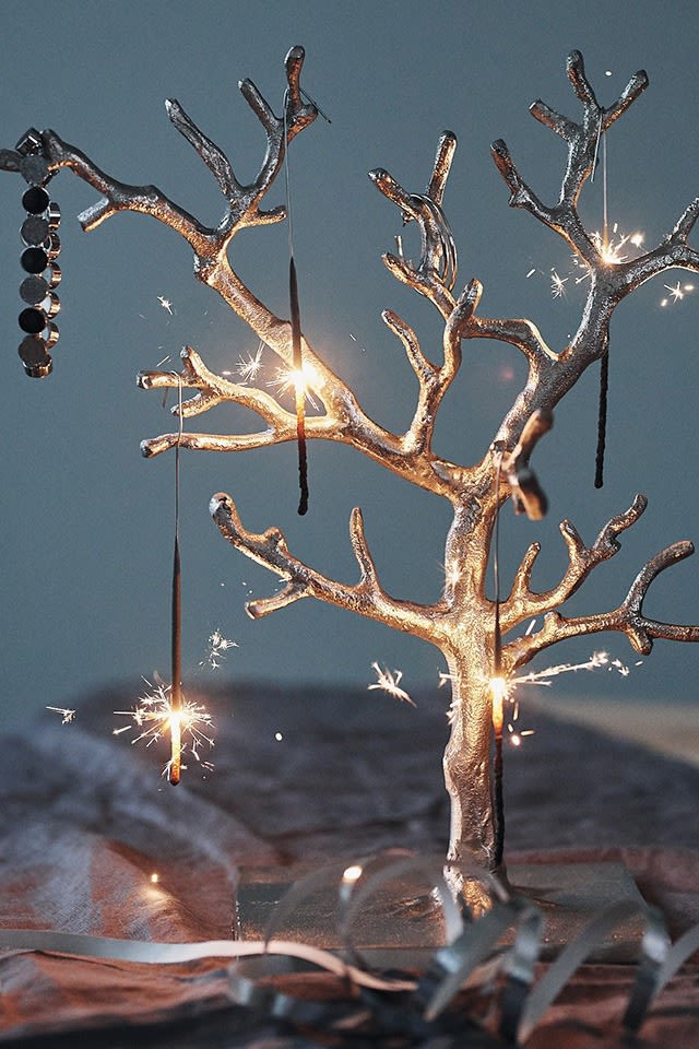 Smyckesträd i silver från Lene Bjerre är dekorerat med tomtebloss för härlig stämning på nyårsfesten. 