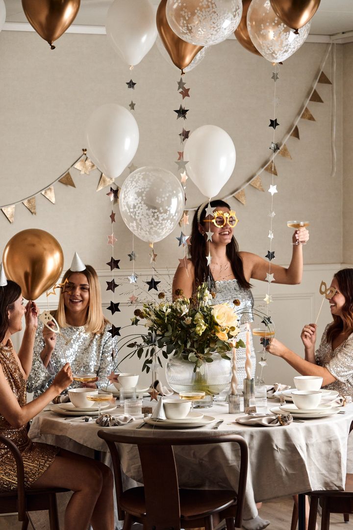Årets nyårsdukning 2023 är en pampig sådan med ballonger, girlanger, partyhattar och med detaljer i guld och silver.