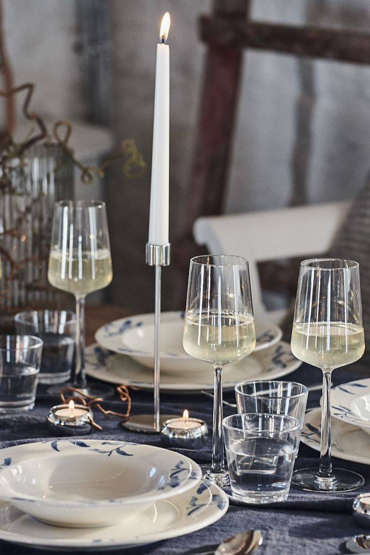Essence vitvinsglas skänker denna blåvita dukning ett elegant uttryck tillsammans med ljusstakar i krom från Cooee Design. 