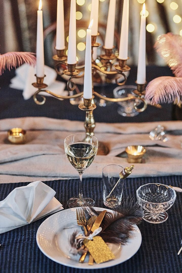 Tallrikskuvert på nyårsdukning bestående av Swedish Grace tallrik vit, guldbestick från Bitz och Chateau vinglas från Orrefors för en nyårsfest med Gatsby-tema.