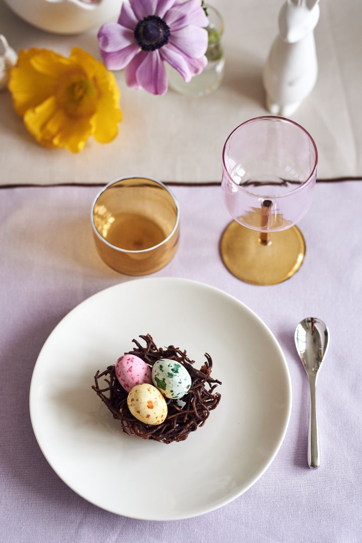 Skapa en festlig påskdukning i vårens pasteller med goda chokladfågelbon på Arabia tallrik tillsammans med Tint glas och vinglas från HAY.