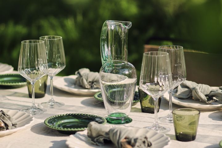Skapa en sommardukning i trädgården med Orrefors Nobel kanna, Iittala Kartio glas, Spiegelau Lifestyle vinglas, Mateus Oyster och PotteryJo Daria assietter.